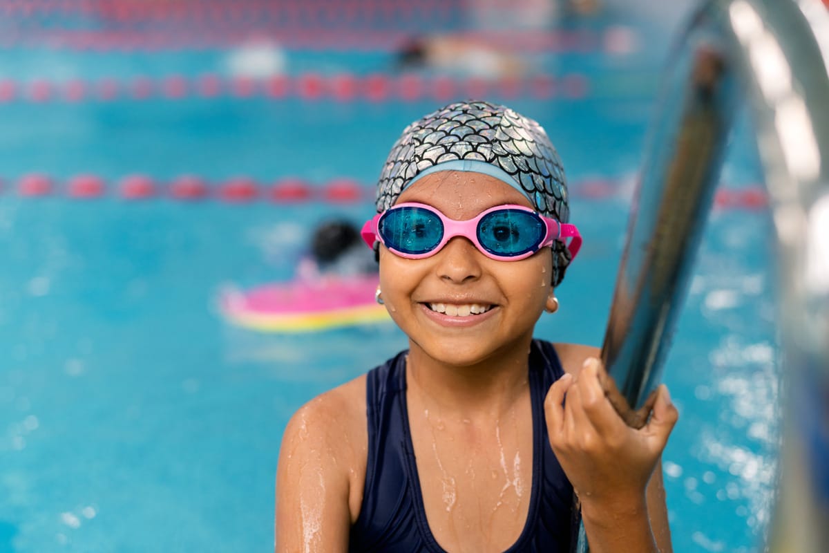 Happy child learning swimming lessons in pool Amsterdam-West zwemschool